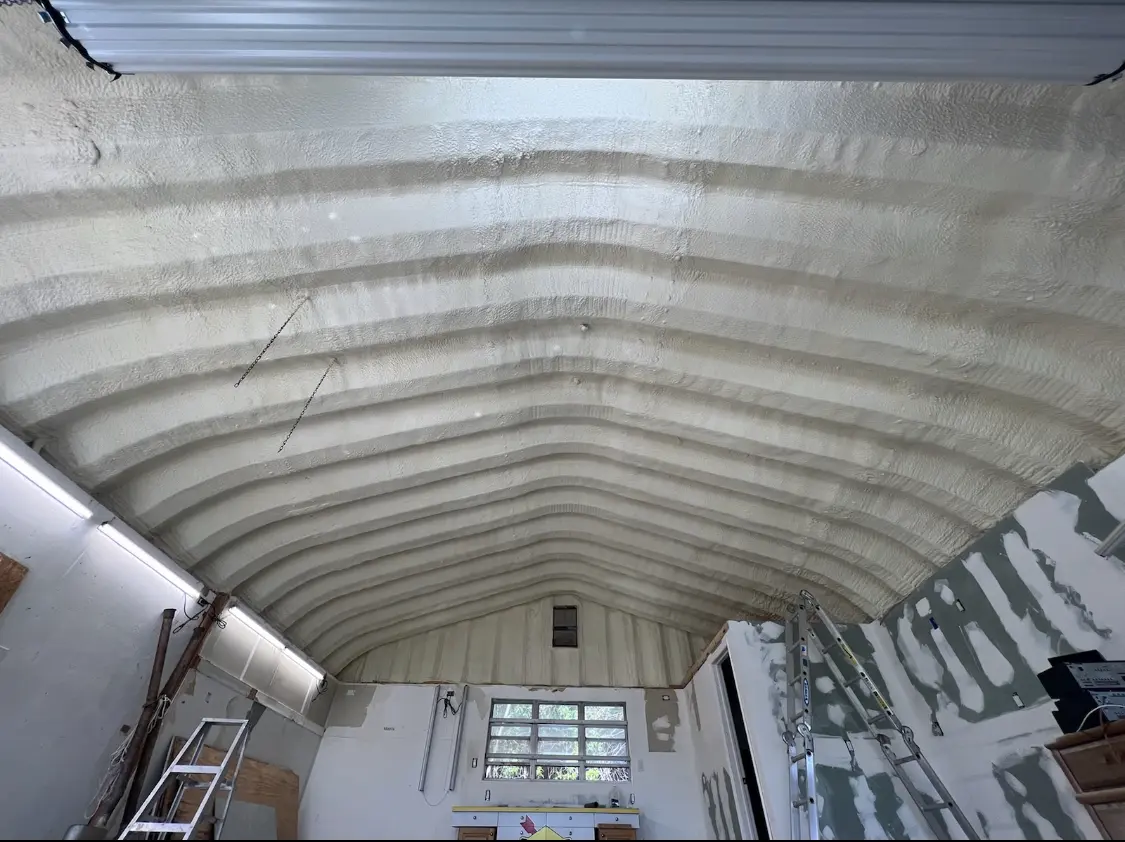 Spray polyurethane foam applied to the underside of a metal roof deck in Rome